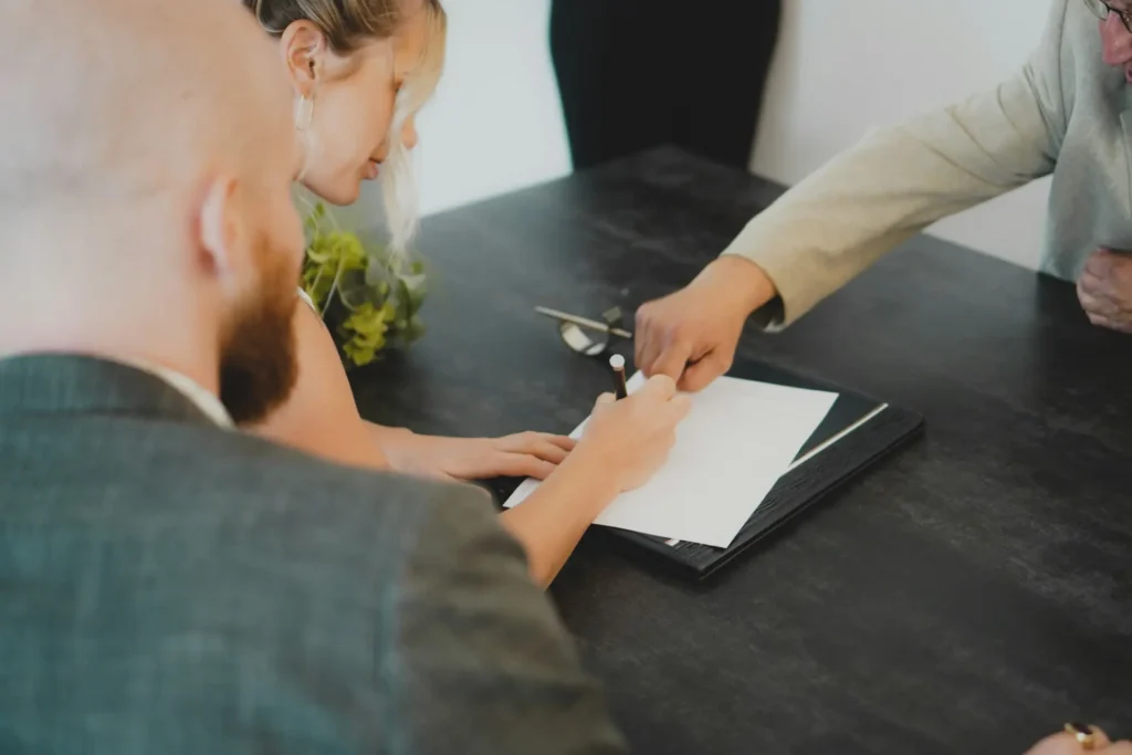 Business owners signing company registration paperwork with an advisor