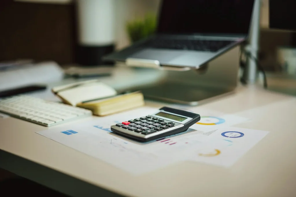 Tax consulting services South Africa – calculator and financial charts on a desk beside a laptop